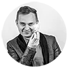 Quiz magiczny Damiana Spętanego Damian Spętany widoczny od pasa w górę, trzyma świecącą się żarówka, która nie jest podłączona do prądu.